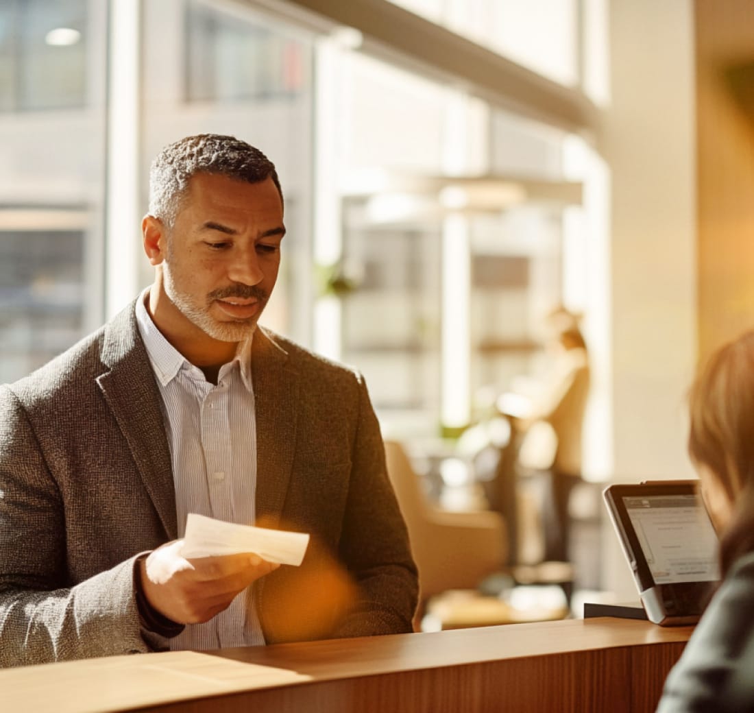 A bank customer depositing a check with support from a bank teller.