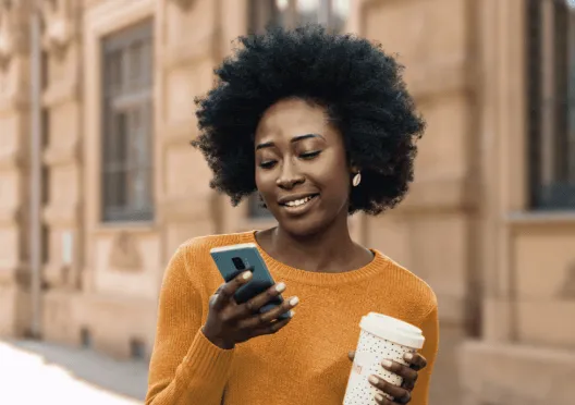 A woman checking her phone while on a coffee run