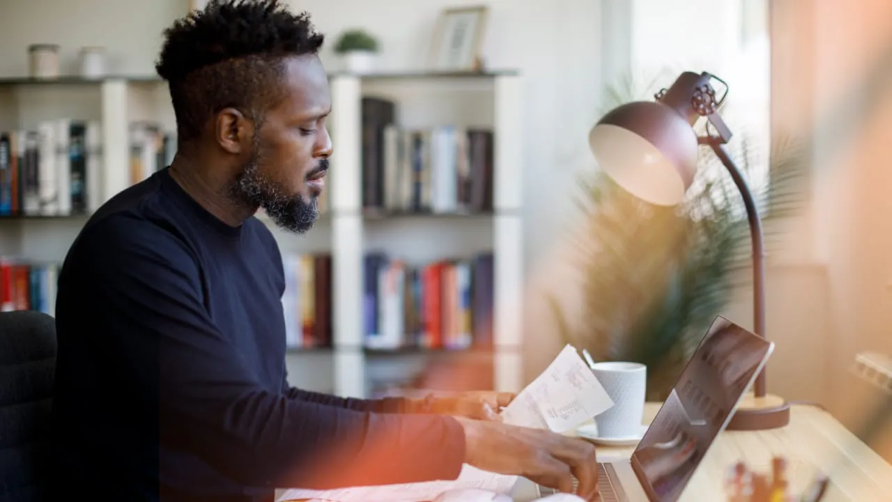 Man sitting at desk on computer laptop