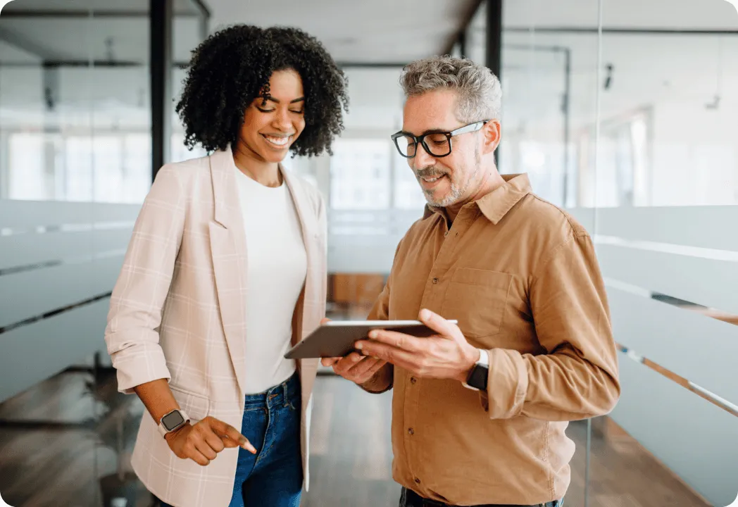 Two people reviewing something on a tablet device