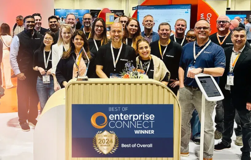 RingCentral employees at a trade show booth, celebrating 2024 "Best of Enterprise Connect" award